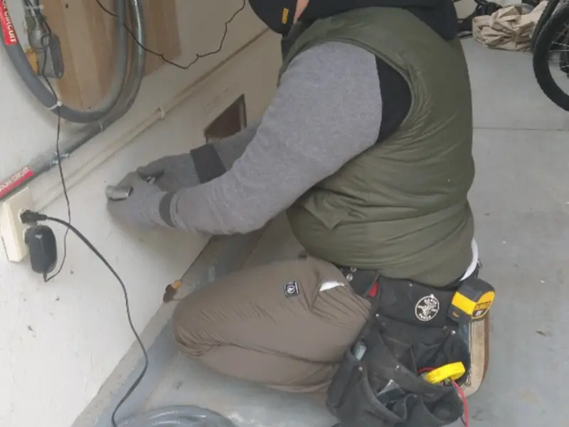 Electrician performing outlet wiring in a Walnut garage
